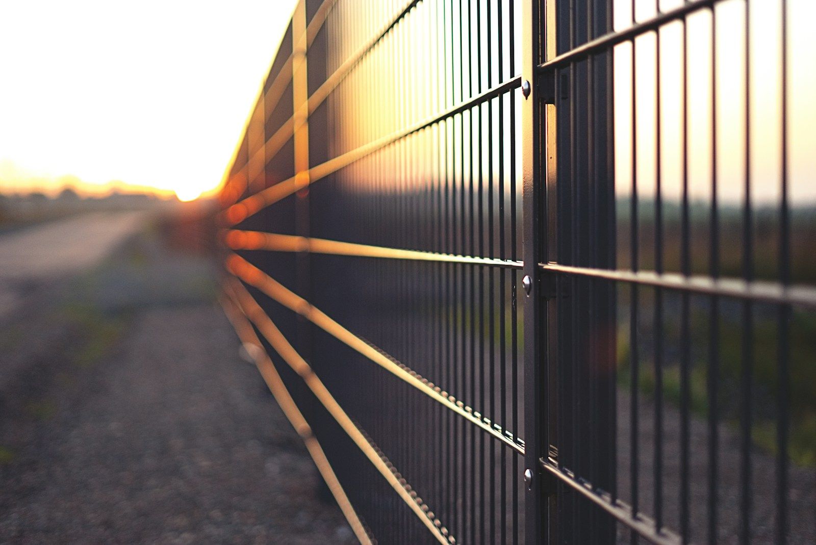 Detalj panelne metalne ograde sa stubovima duž puta